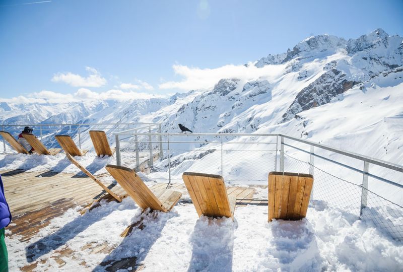 deck chairs on a sunny, snowy sun terrace