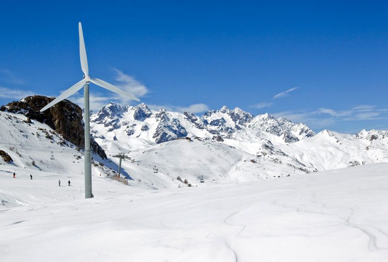 A wind turbine is pictured in a snowy ski resort