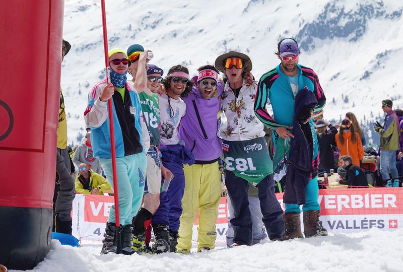 A group dressed up pose for the camera, all standing on the snow