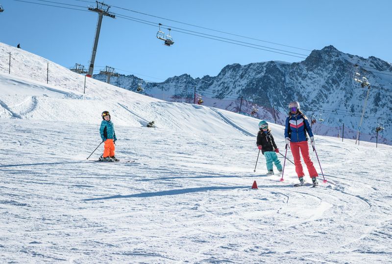 A family skis on a gentle slope near the lift